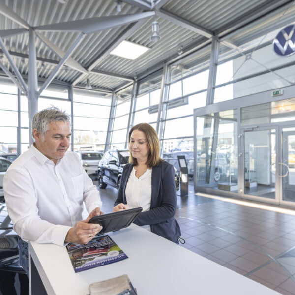 one guy explaining something on a tablet to a woman