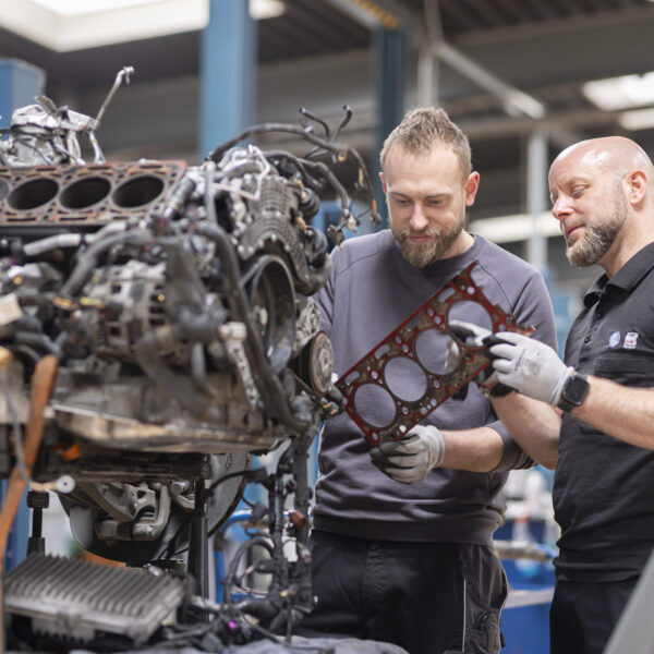 two man repairing an engine